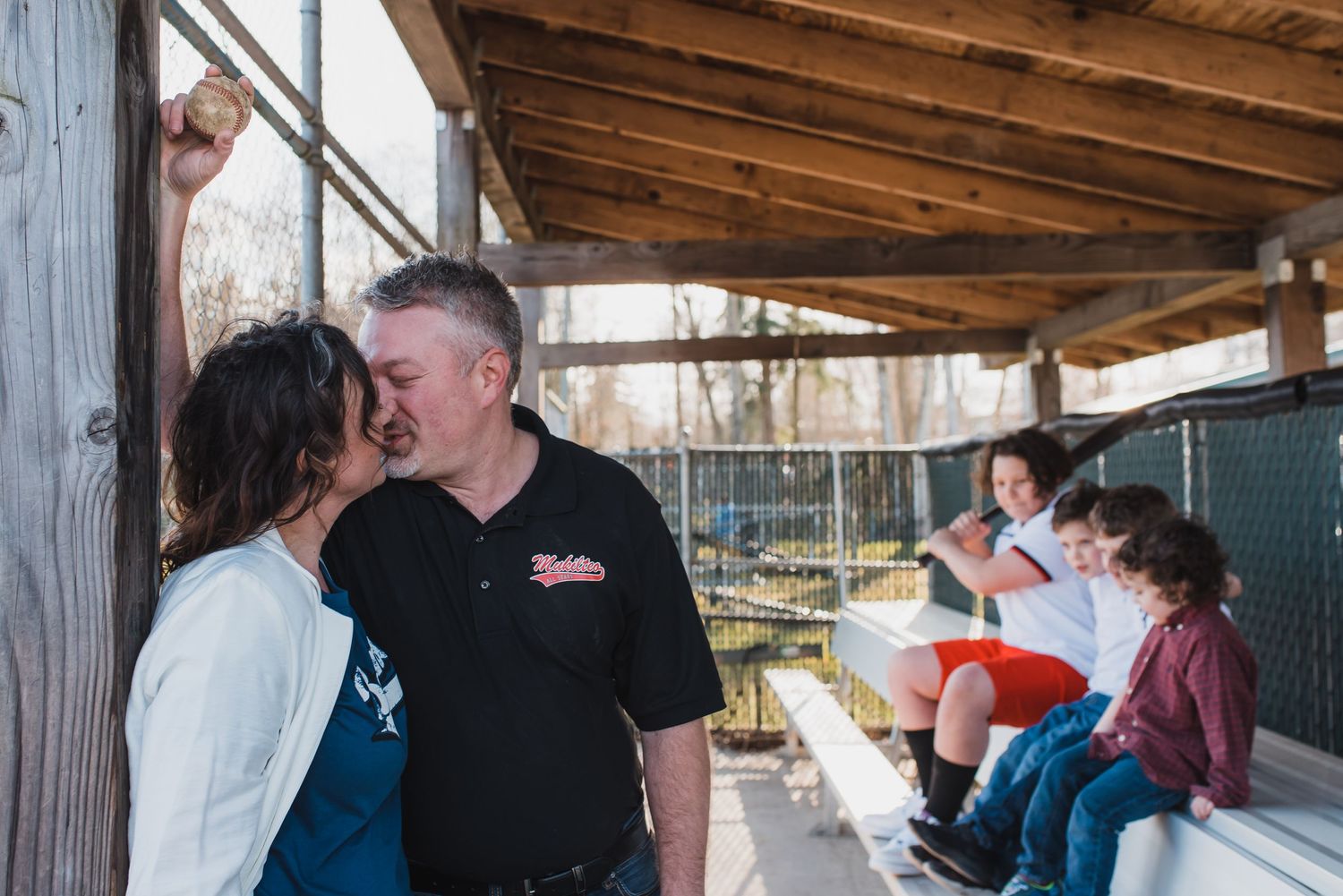 Parents and their 4 boys in dugout at Mukilteo Little League fields