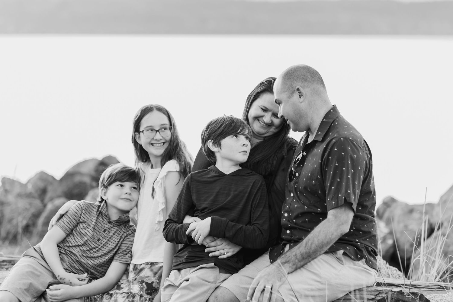 A series of black and white photos showing people sitting and socializing outdoors in a casual setting.