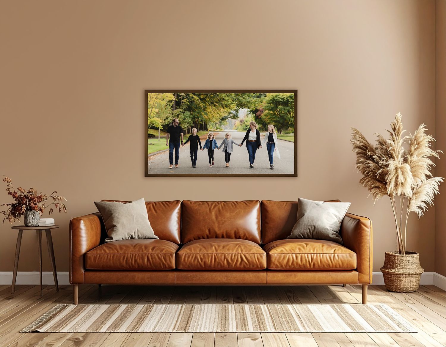 Modern living room with brown leather sofa and large framed photo above the couch of a family walking and holding hand in Snohomish, WA.