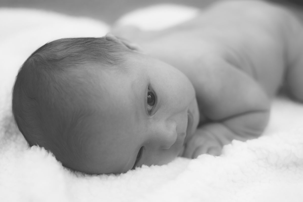 black and white image of baby boy on his stomach