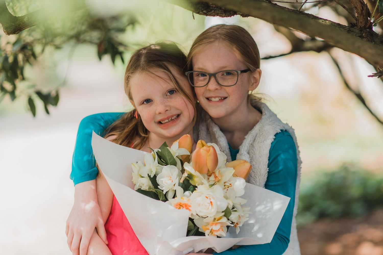 A heartwarming embrace captured outdoors with spring flowers and natural lighting.