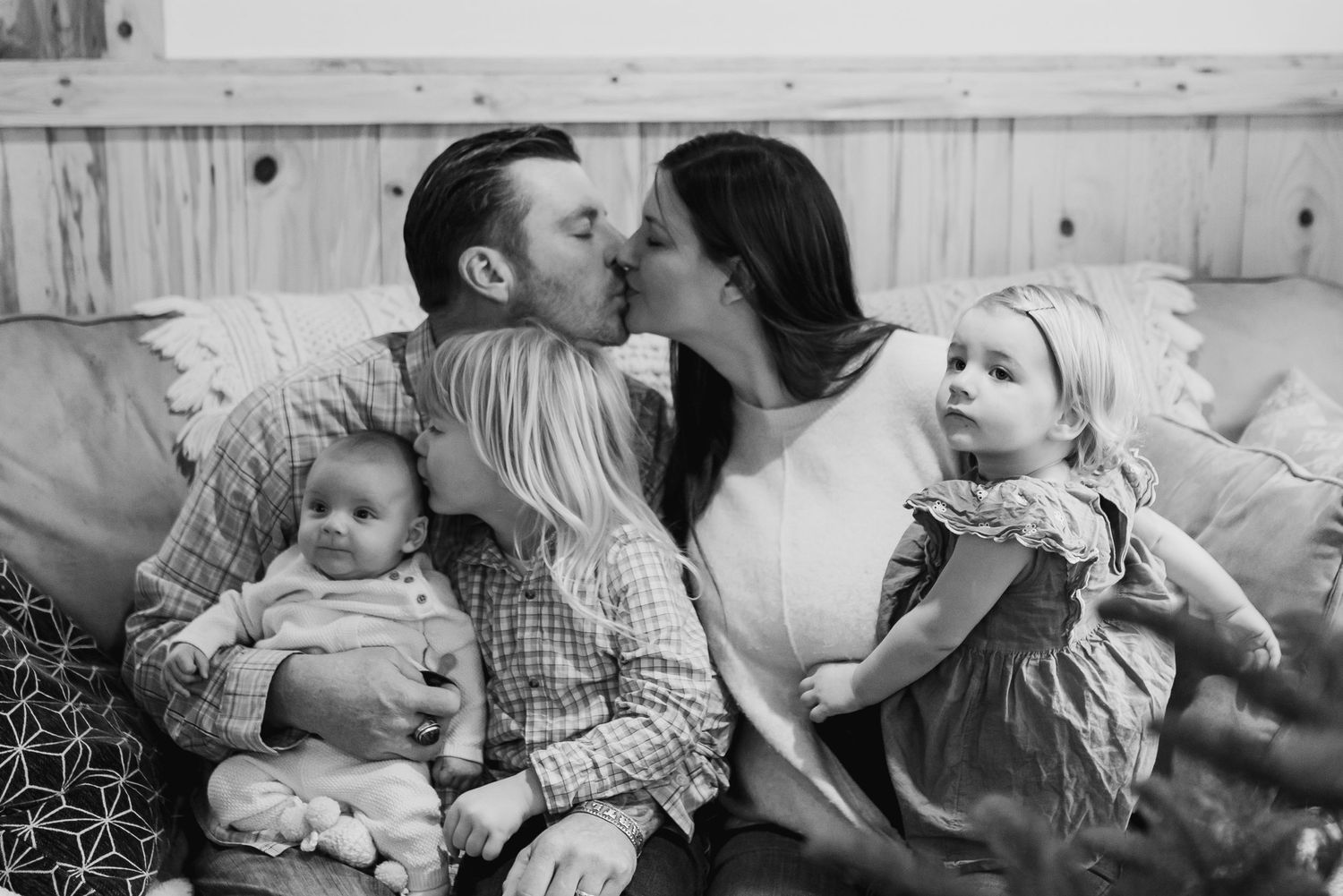 A series of black and white photographs showing tender moments between a parent and baby in various poses.