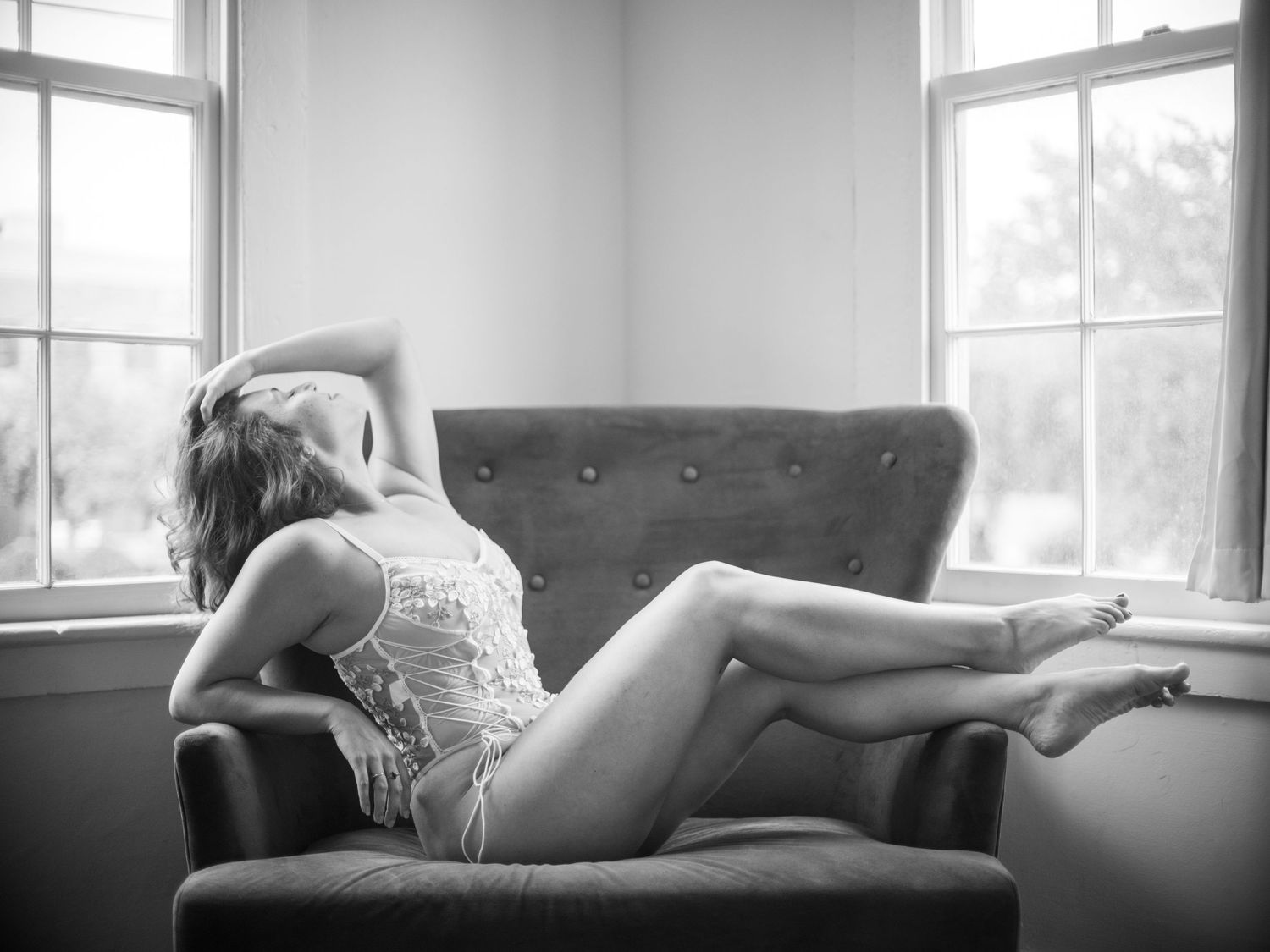 graceful posing in a chair by the window in savannah boudoir studio