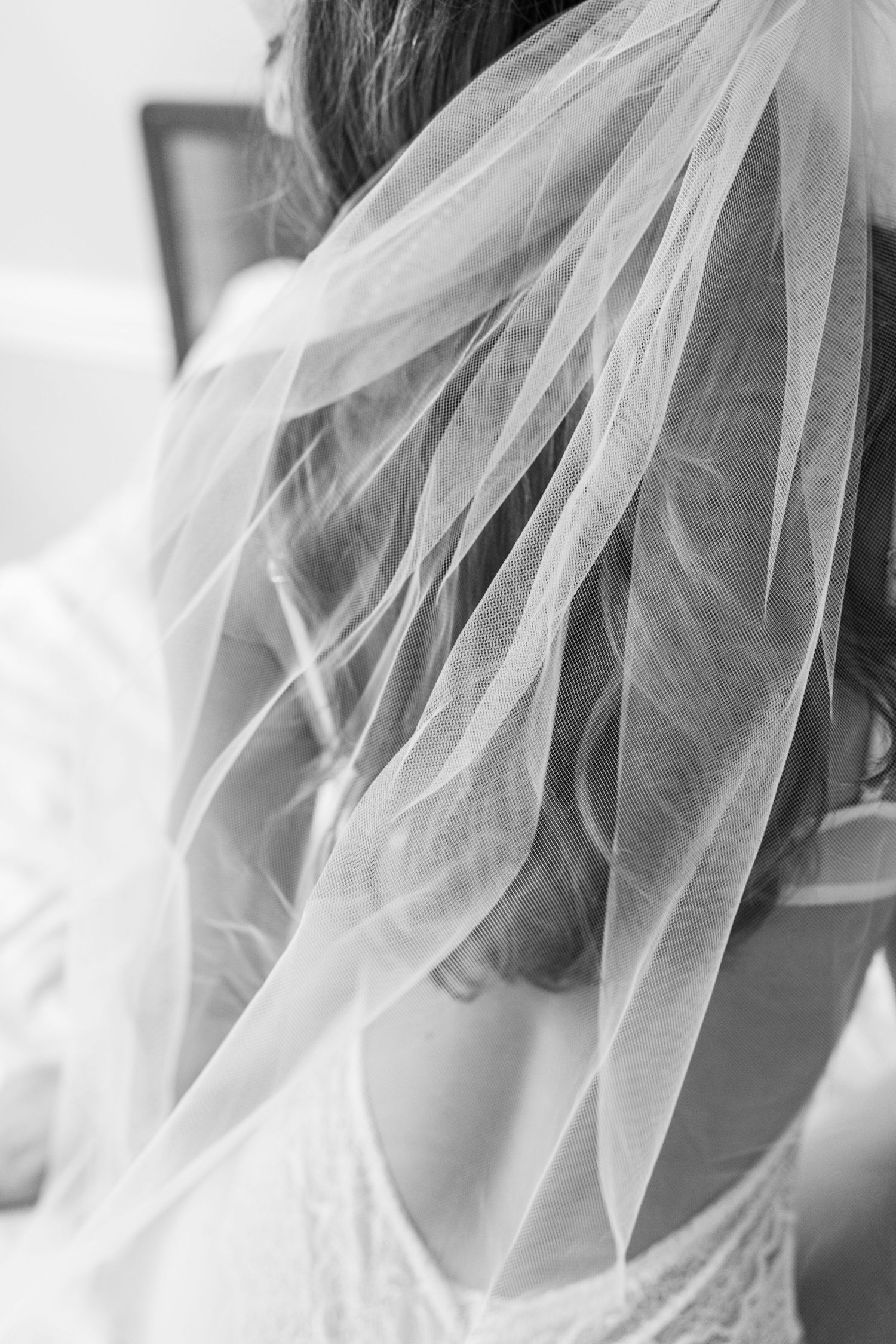 a bridal boudoir photo with a veil and white lace lingerie