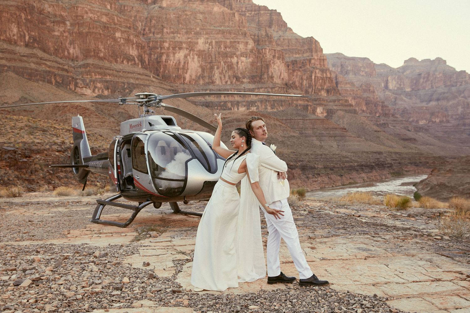 A helicopter landed in the scenic Grand Canyon with people enjoying views of the majestic red rock formations.
