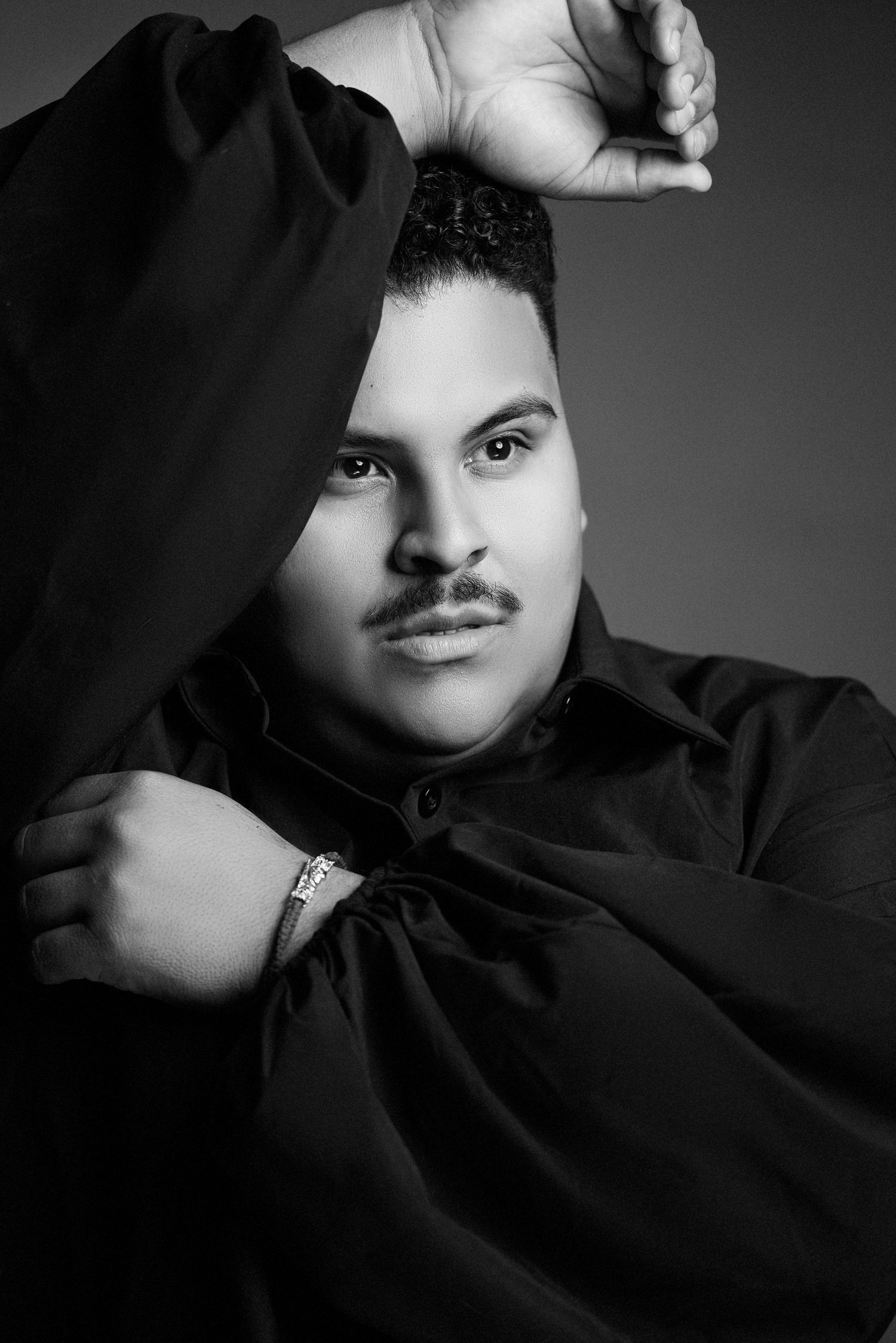 Dramatic black and white portrait series showing different angles of person wearing dark clothing against grey backdrop.