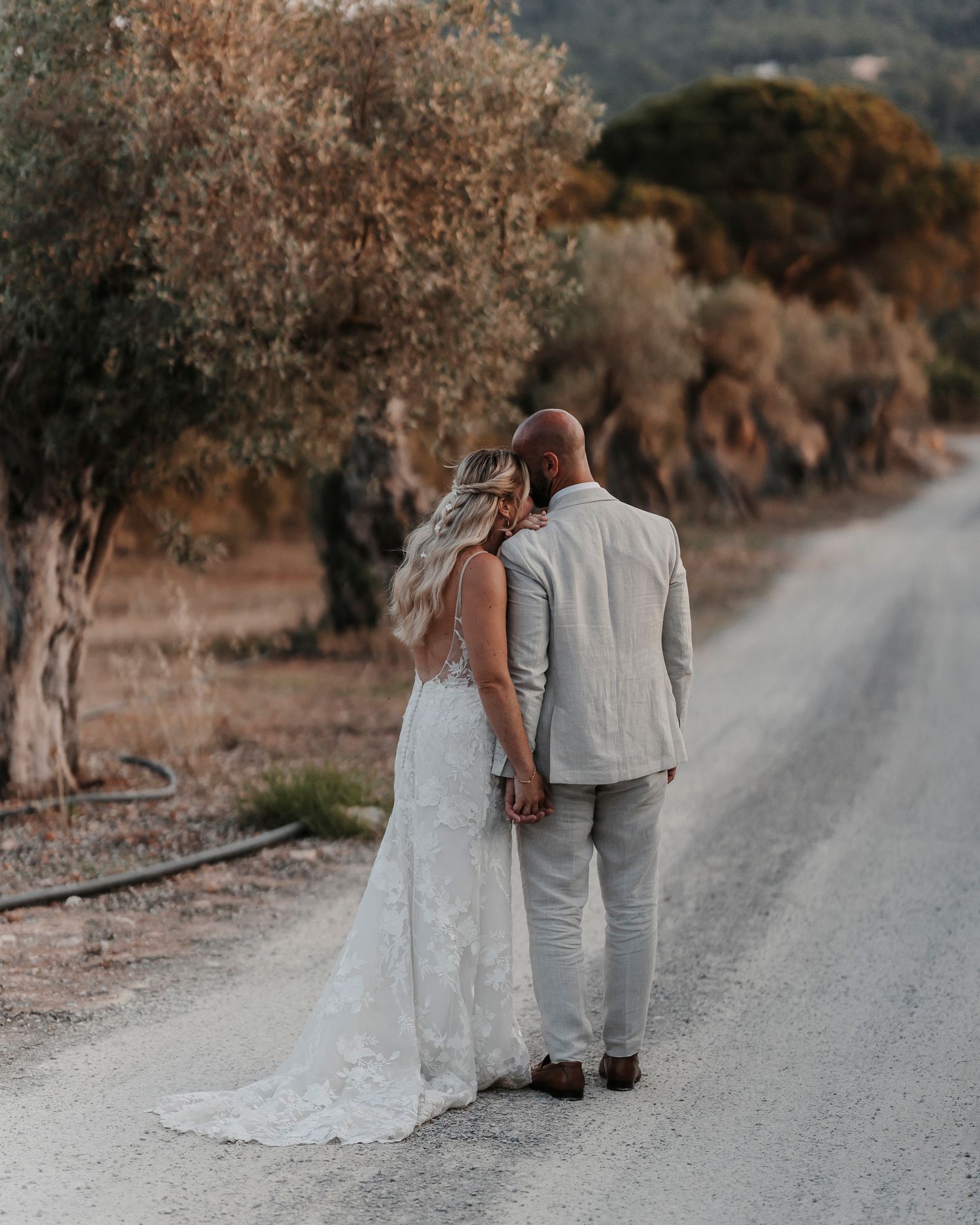 Bride and groom embracing each other whilst near the olive trees at their Ibiza wedding.