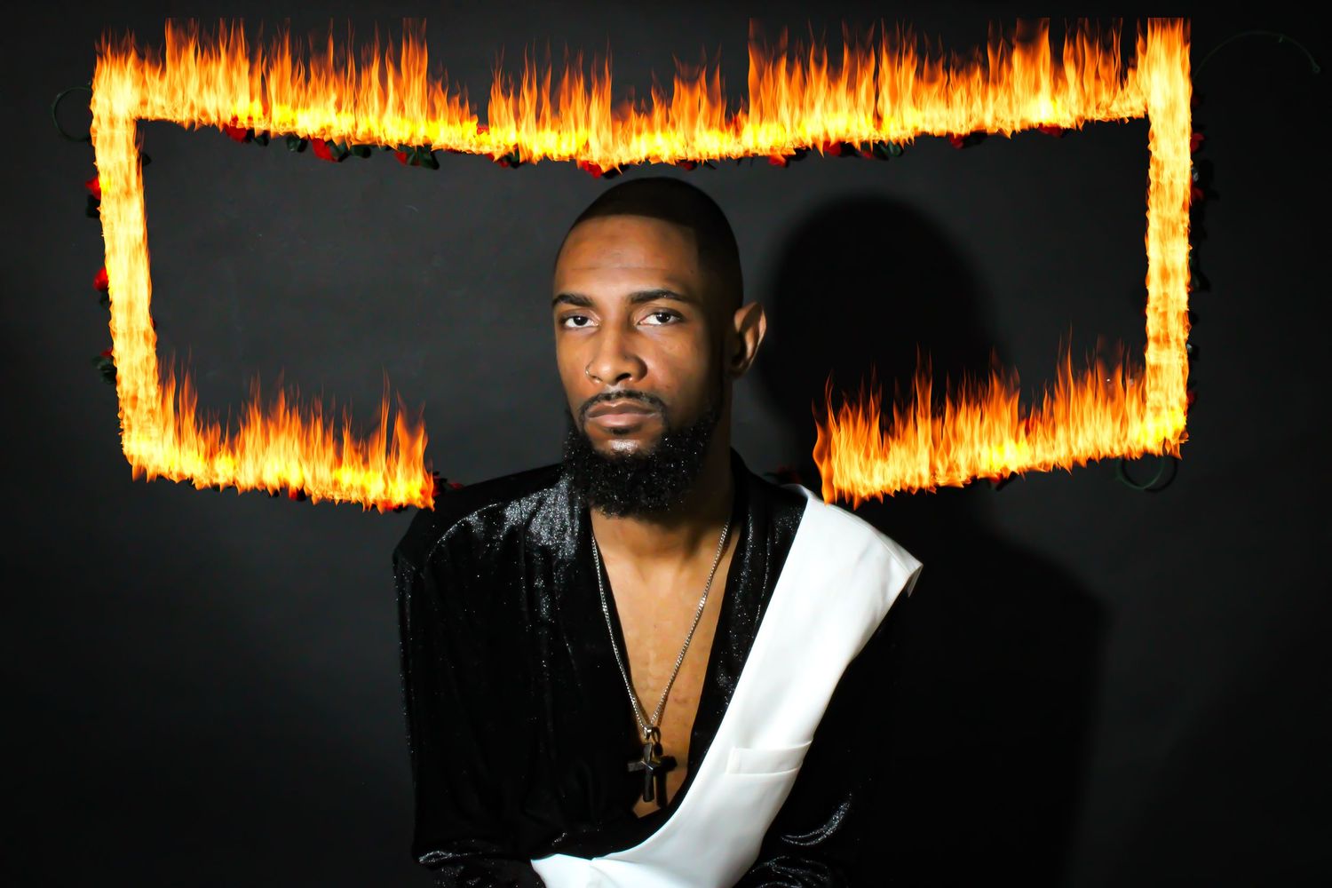 Dramatic studio portrait with glowing fire frame effect against black background.