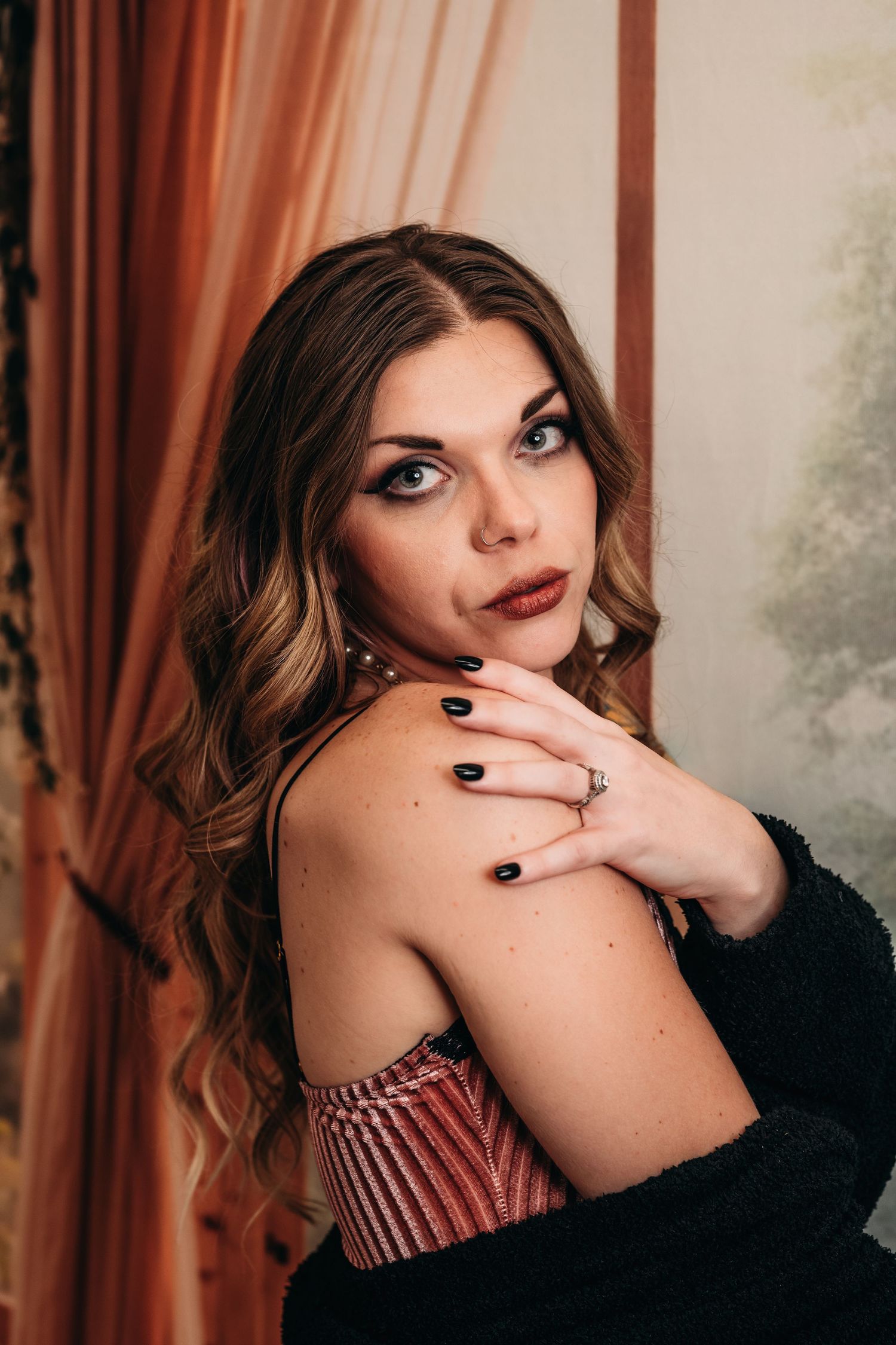 Women with wavy brown hair wearing dark lipstick  moody indoor setting.  Nice & Naughty Boudoir Photography Grand Rapids, MI.