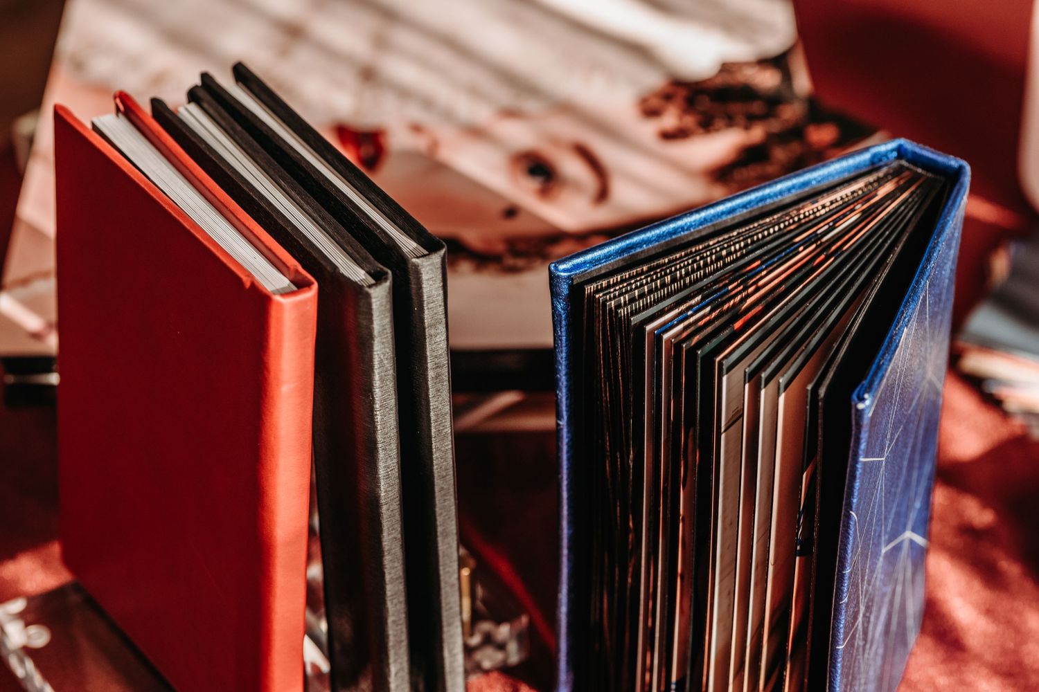 A close-up view of vinyl records arranged vertically on a red shelf shows their spines and edges.