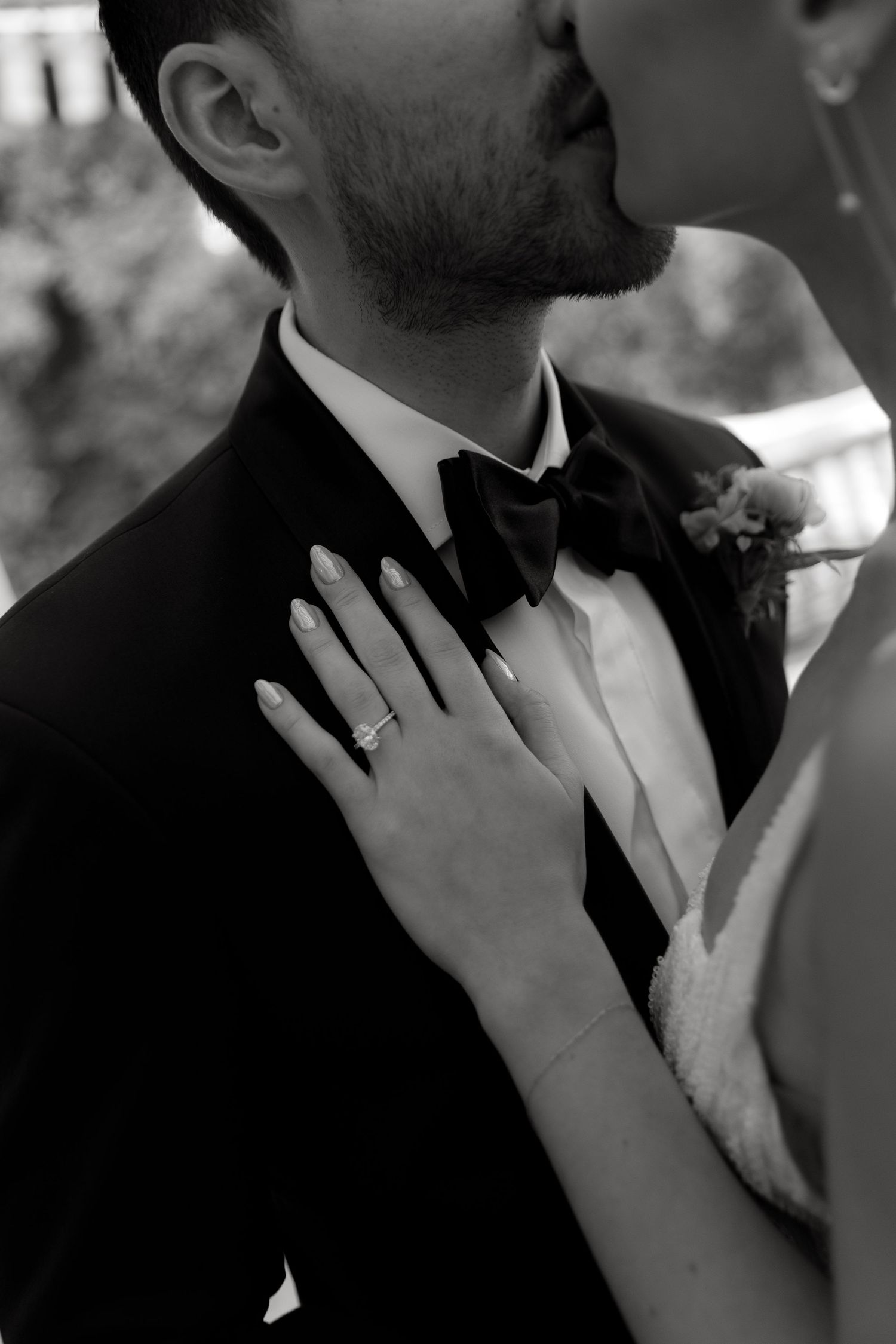 A close-up series of intimate wedding couple shots showing hands touching and embracing in black and white.