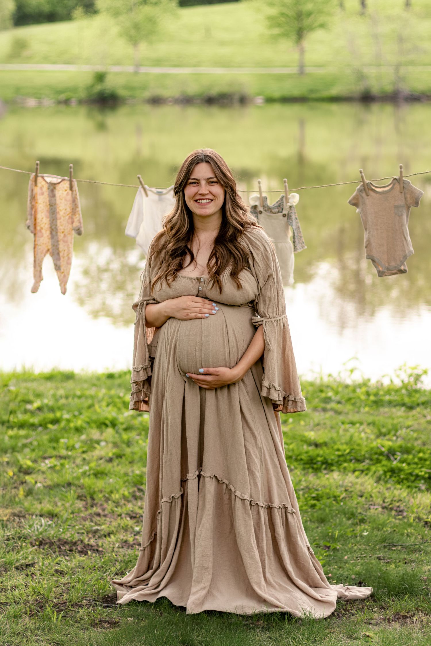 A series of maternity photos showing a woman in a flowing beige dress posing near a tranquil pond in a lush green setting.