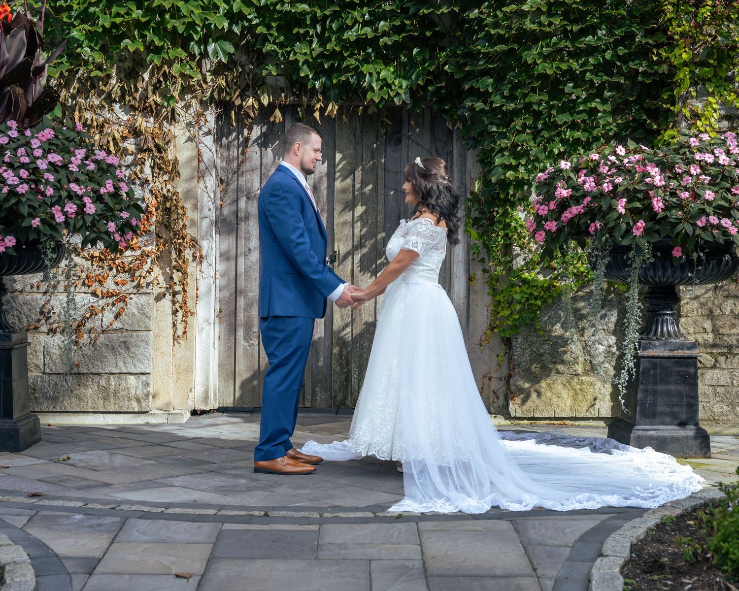A bride and groom hold hands in a romantic outdoor wedding portrait, telling part of their love story.