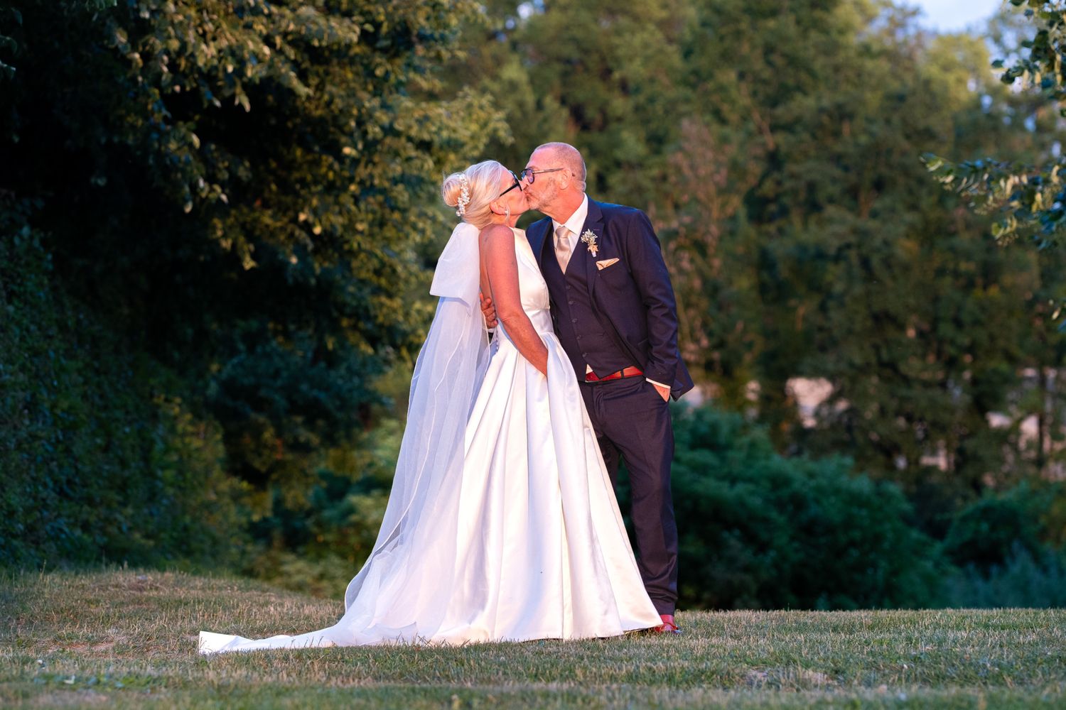 Photographie de mariage durant la Goldent Hour de deux mariés s'embrassant de face par le photographe professionel Jérémie Botte.