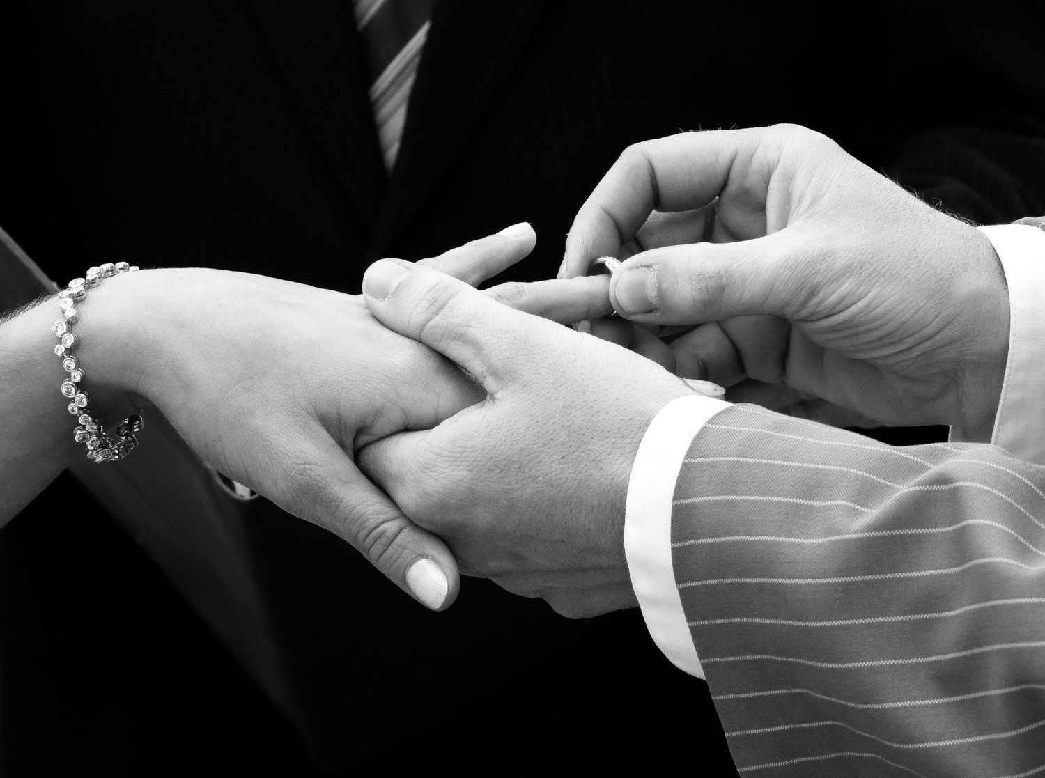 Gros plan en noir et blanc sur l'échange des alliances lors d'une cérémonie de mariage, par Jérémie Botte.