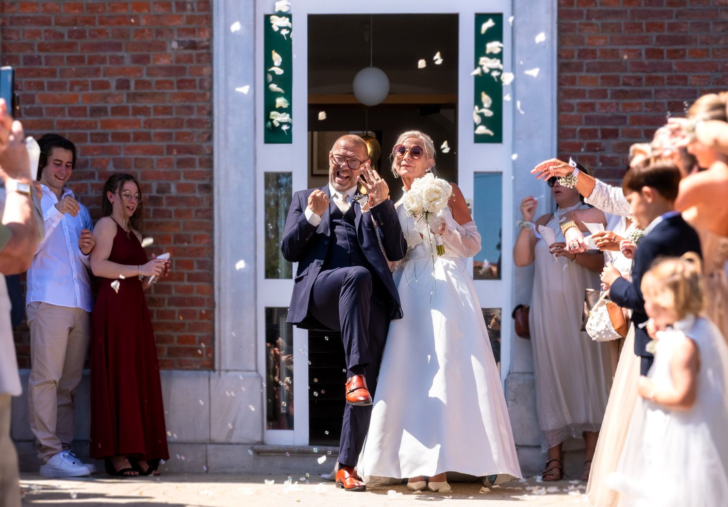 Photographie de mariage en exterieur de jour des deux mariés à la sortie de la cérémonie par le photographe professionel Jérémie Botte.