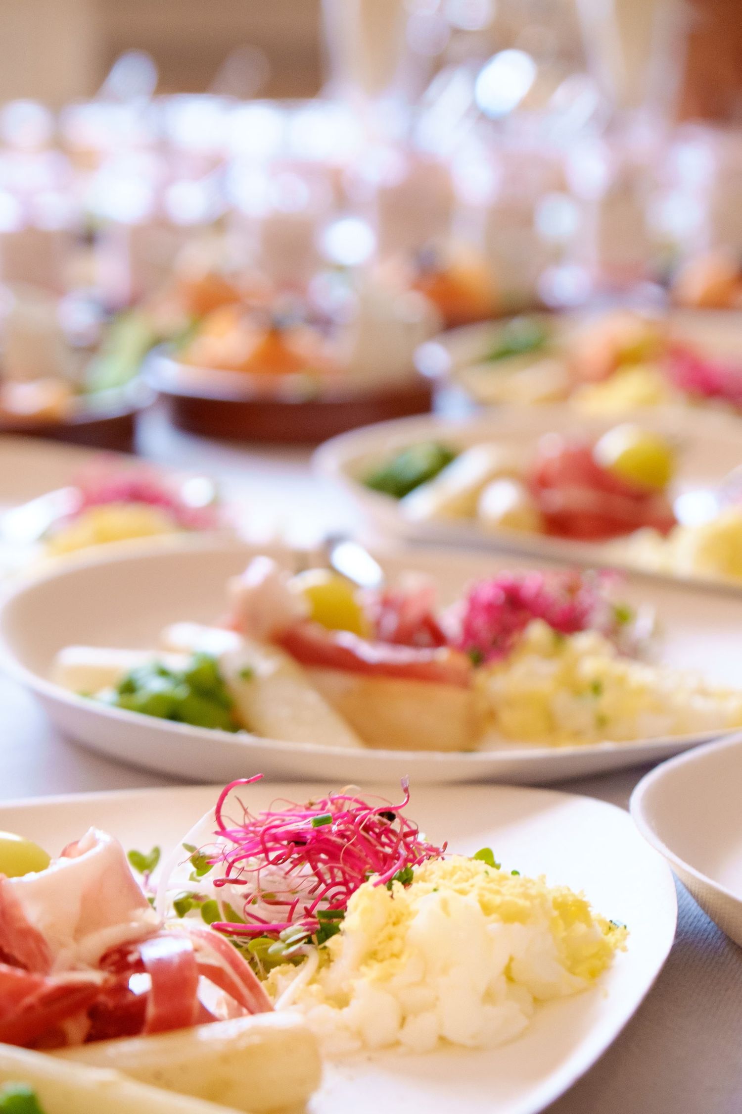Une perspective sur un buffet de réception présentant une multitude d'assiettes d'entrées prêtes à être servies, photo de Jérémie Botte.