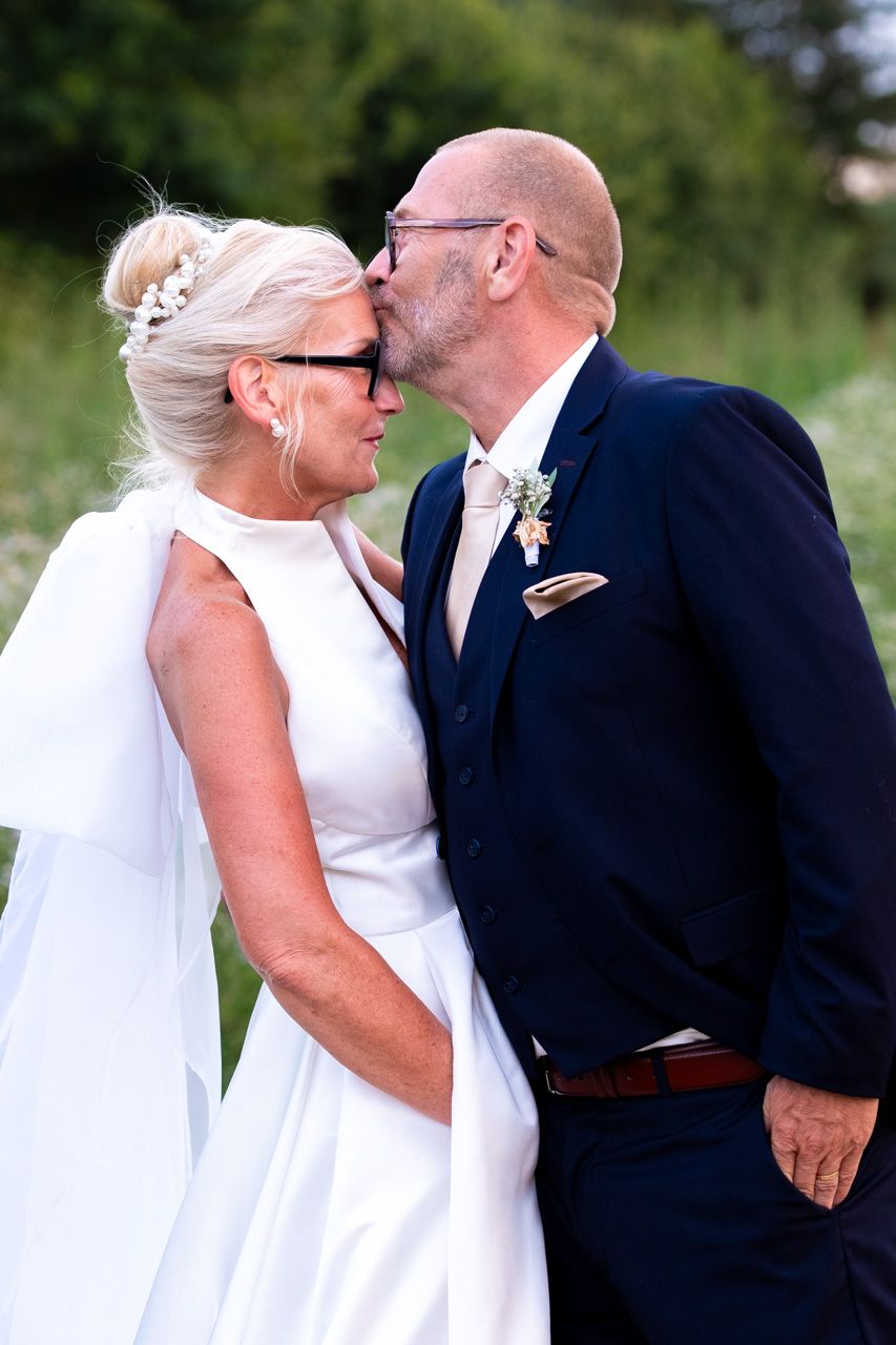 Photographie de mariage de mariés tout sourire de jour s'embrassant par le photographe professionel Jérémie Botte.