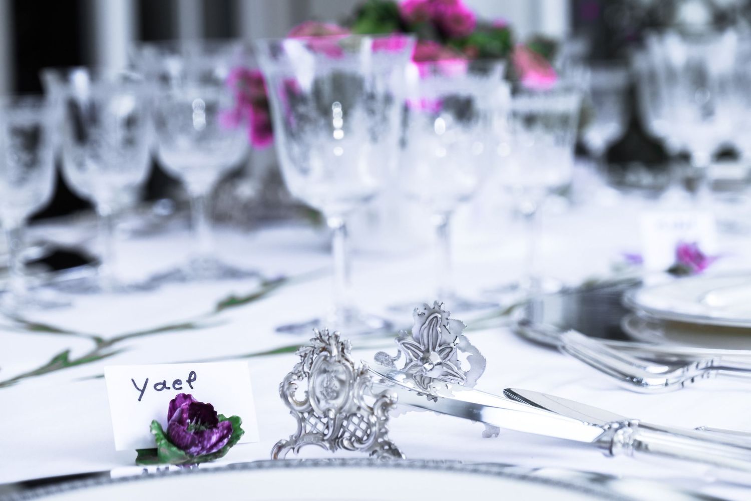 Vue rapprochée de la décoration d'une table de fête élégante, mettant en évidence un carton de placement au nom de 