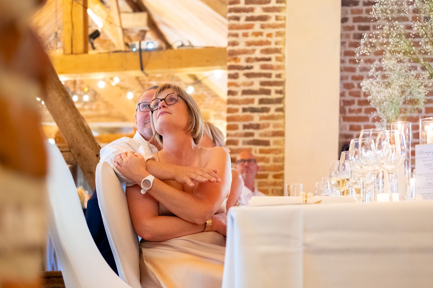 Photographie de mariage en intérieur d'invités observant des photos souvenirs par le photographe professionel Jérémie Botte.