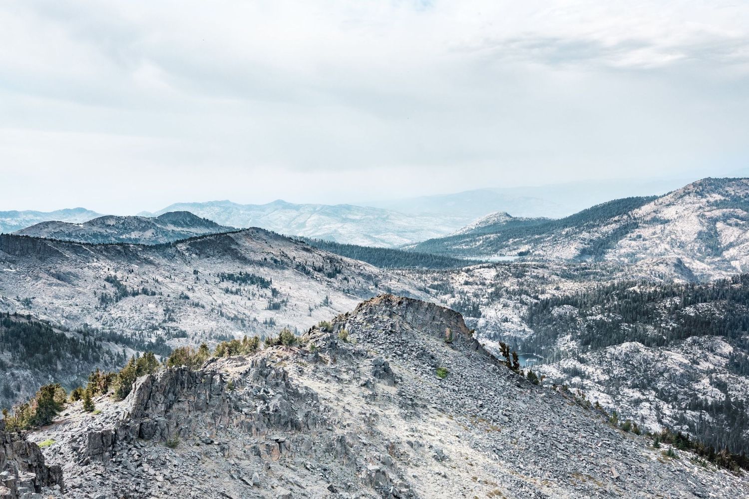 Panorama sur des sommets rocheux et une vallée aride sous un ciel couvert aux États-Unis, par Jérémie Botte.
