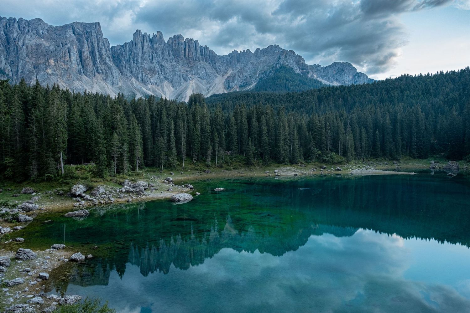 Les montagnes des Dolomites se reflètent dans les eaux vertes et calmes du lac de Carezza par Jérémie Botte.