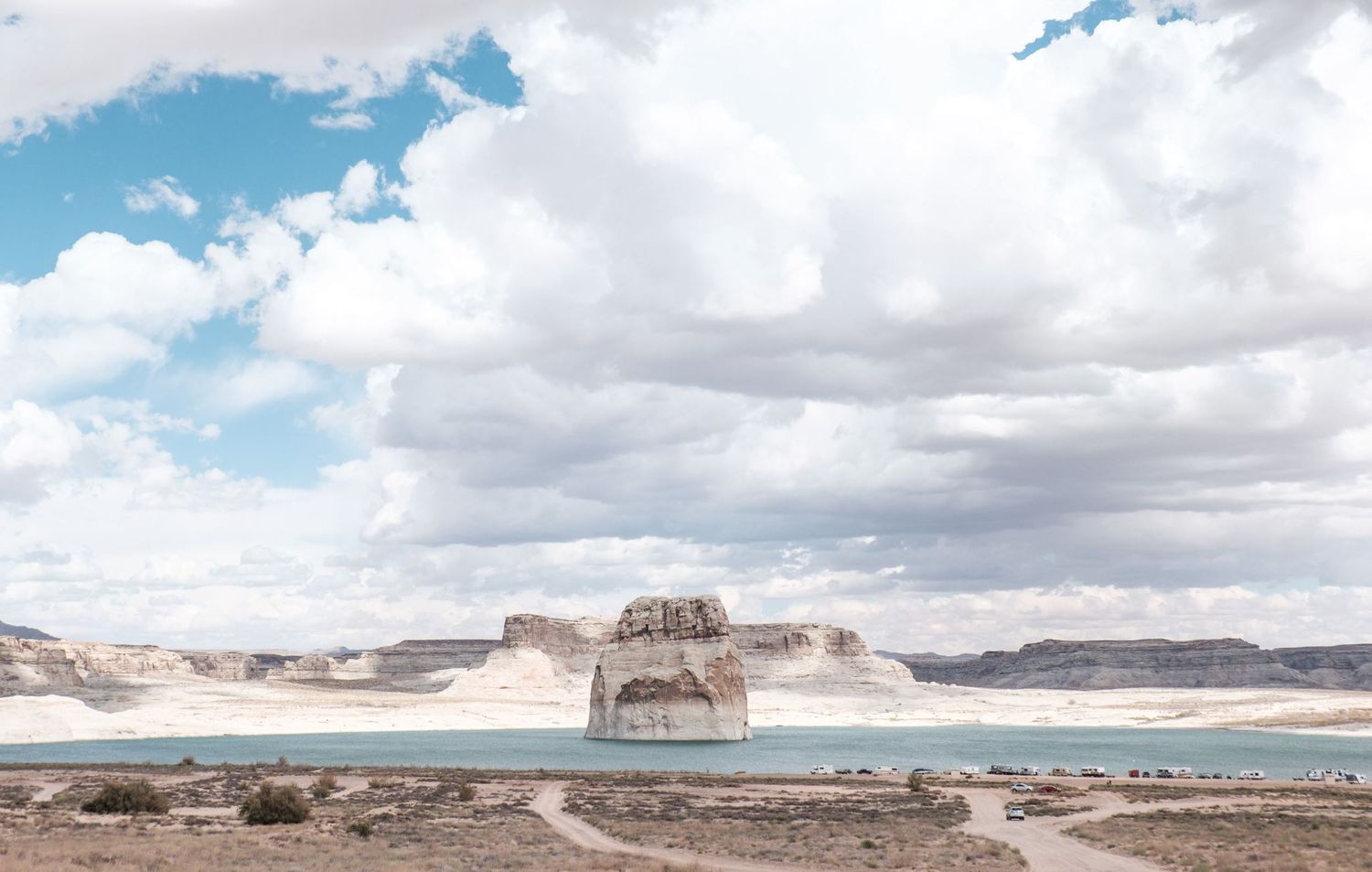 Une formation rocheuse s'élevant au milieu du lac Powell sous un ciel nuageux aux États-Unis, par Jérémie Botte.