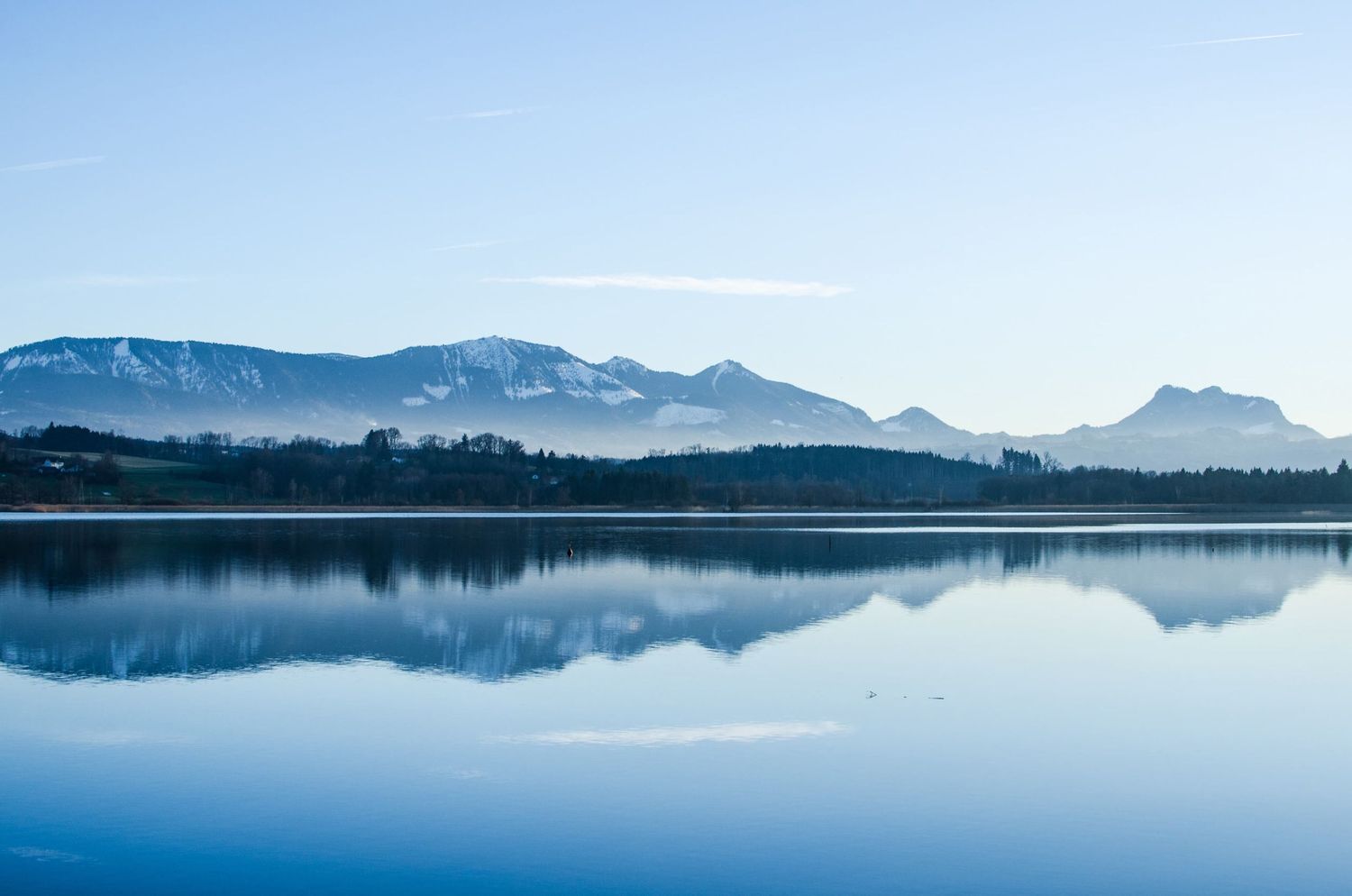 Photographie de paysage en Allemagne montrant un lac calme reflétant des montagnes enneigées au loin par Jérémie Botte.