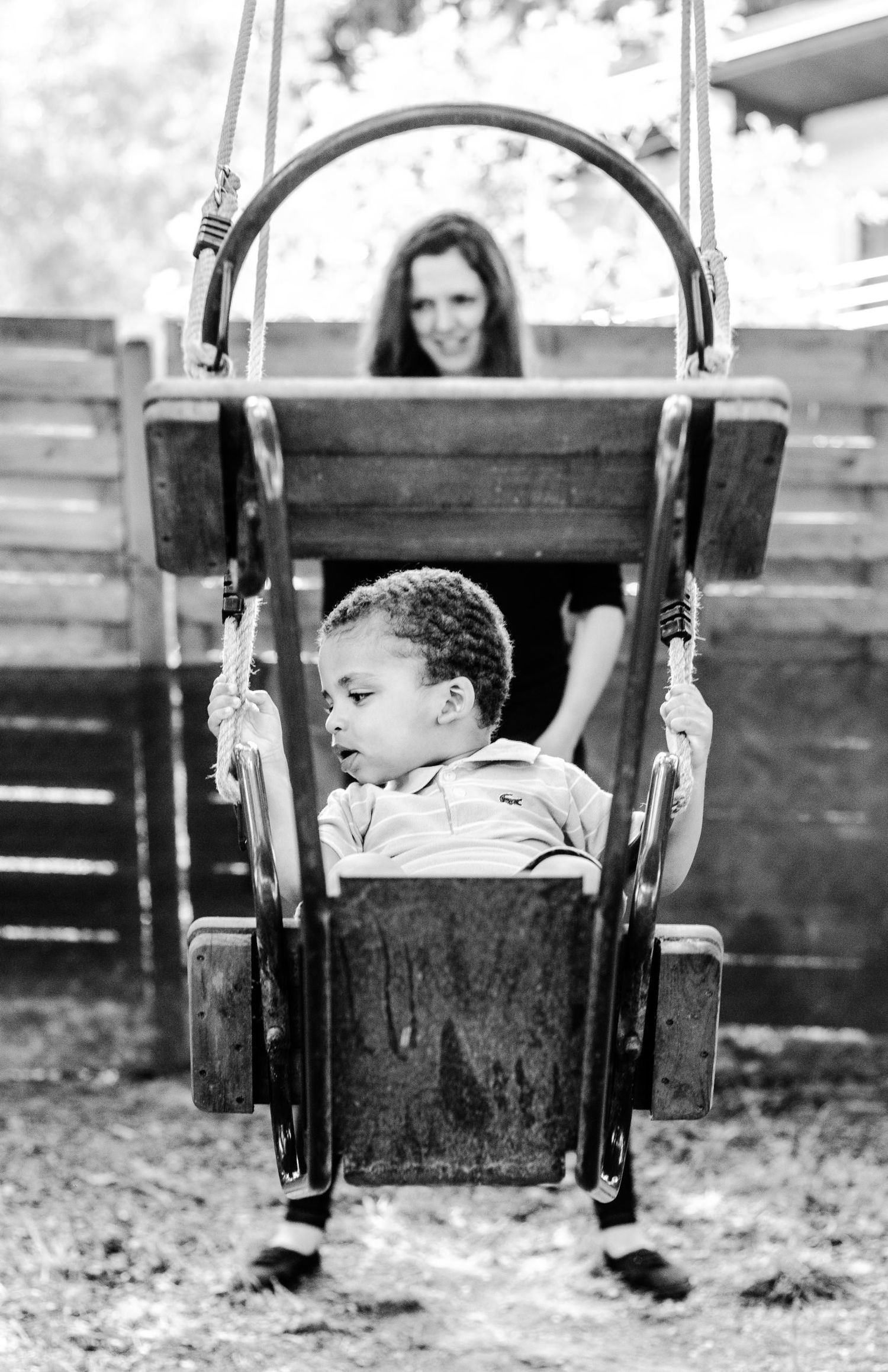 Moment de complicité en noir et blanc entre une mère et son fils sur une balançoir - Photographe Famille Belgique