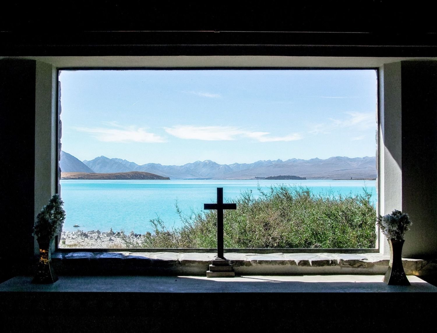 Vue depuis l'intérieur de l'église du Bon-Berger face aux eaux turquoise du lac Tekapo en Nouvelle-Zélande, par Jérémie Botte.