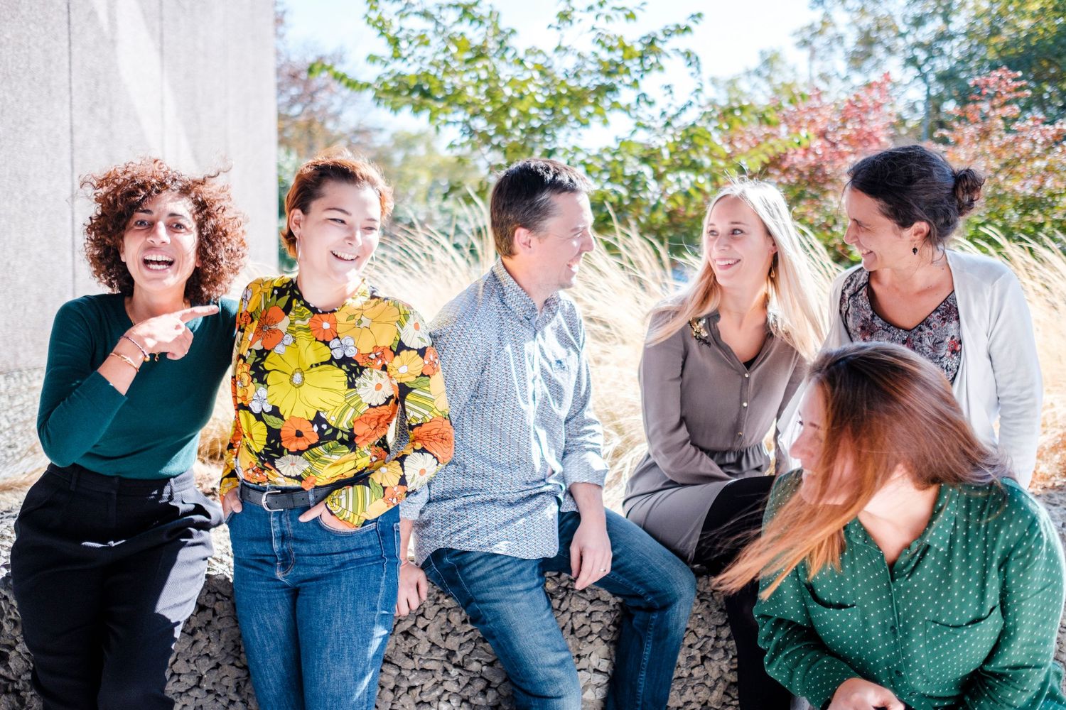 Groupe de collègues souriants en extérieur - Photo portrait corporate dynamique à Bruxelles par Jérémie Botte.