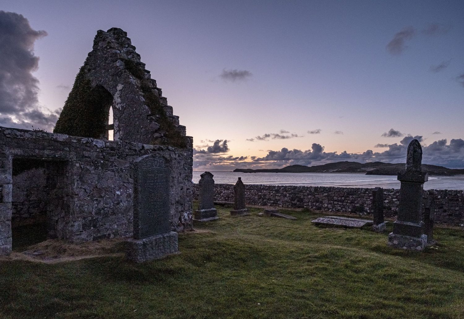 Les ruines en pierre d'une église et son vieux cimetière face à la mer au coucher du soleil par Jérémie Botte.