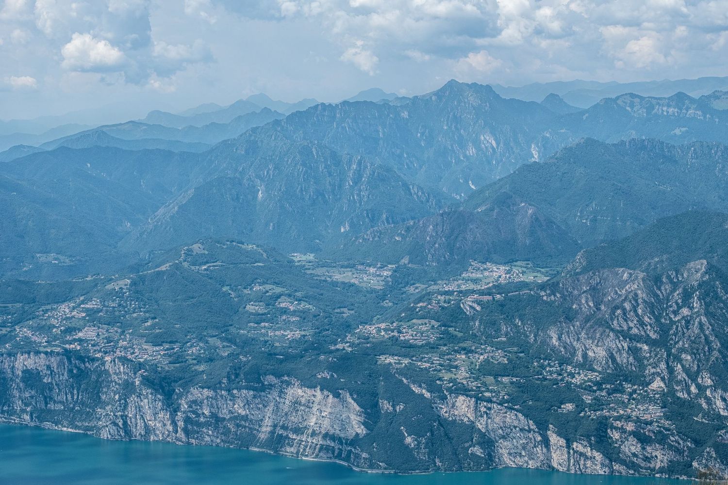 Vue aérienne de montagnes escarpées s'élevant au-dessus du lac de Garde en Italie par Jérémie Botte.