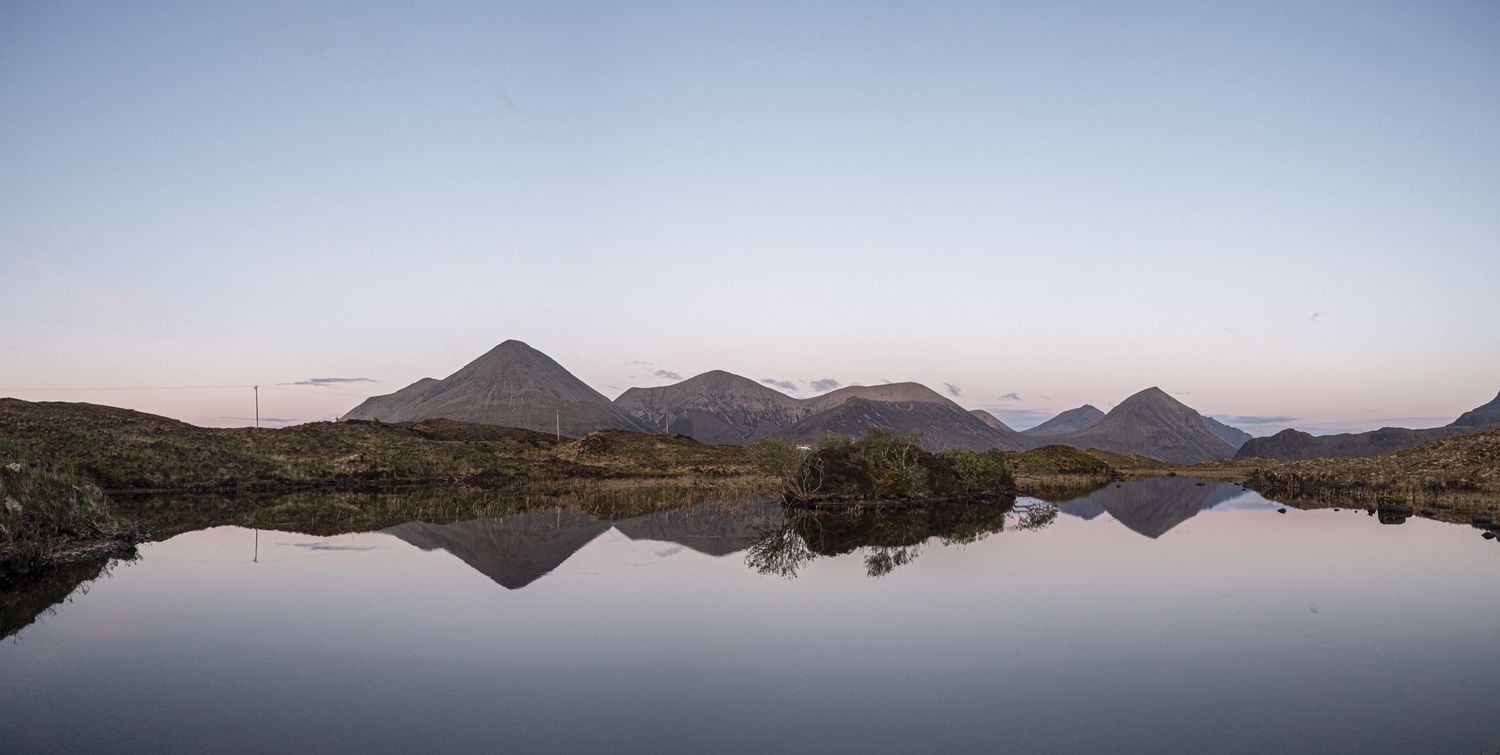 Photographie de paysage en Écosse montrant des montagnes pointues se reflétant sur un lac immobile sur l'ile de Skye par Jérémie Botte.