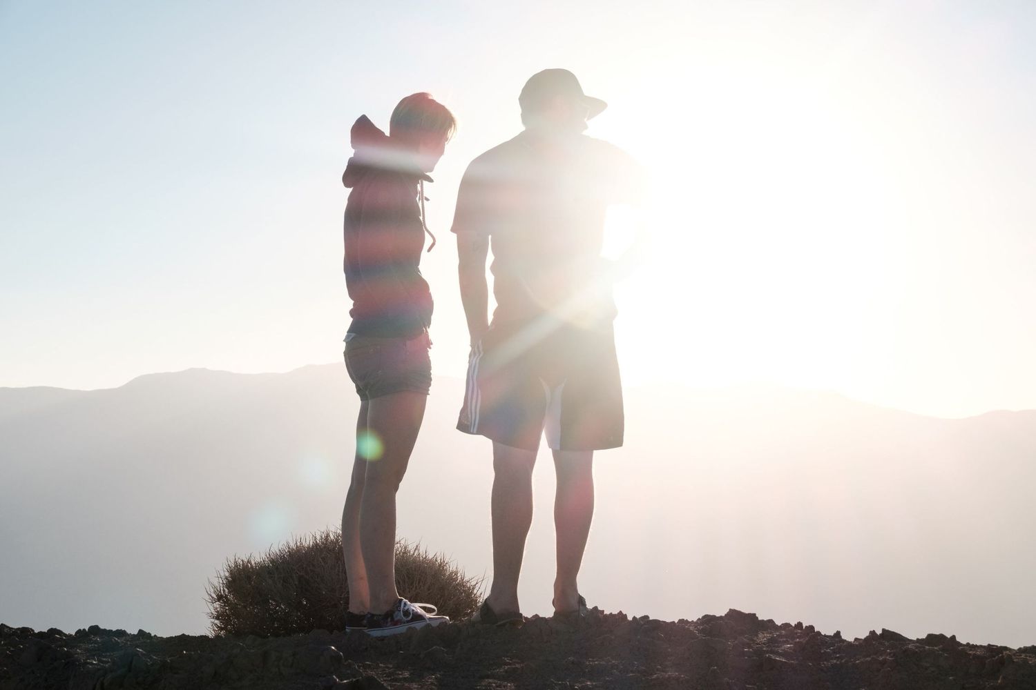Photo à contre-jour montrant la silhouette d'un couple face au soleil au sommet d'une montagne dans la Death Valley NP par Jérémie Botte.