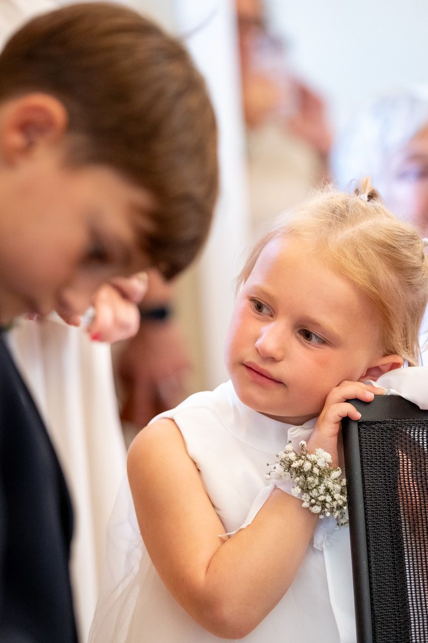 Photographie de mariage en intérieur de jour des deux jeunes invités durant la cérémonie par le photographe professionel Jérémie Botte.