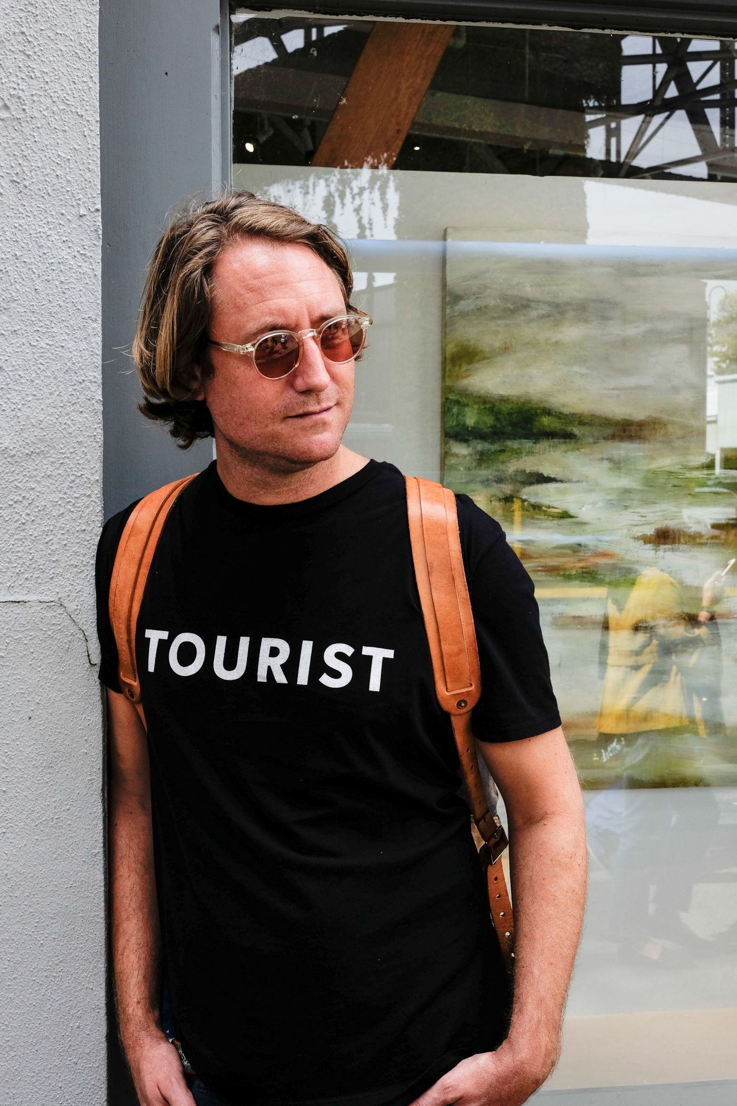 Portrait de profil d'un homme portant des lunettes de soleil et un t-shirt noir 