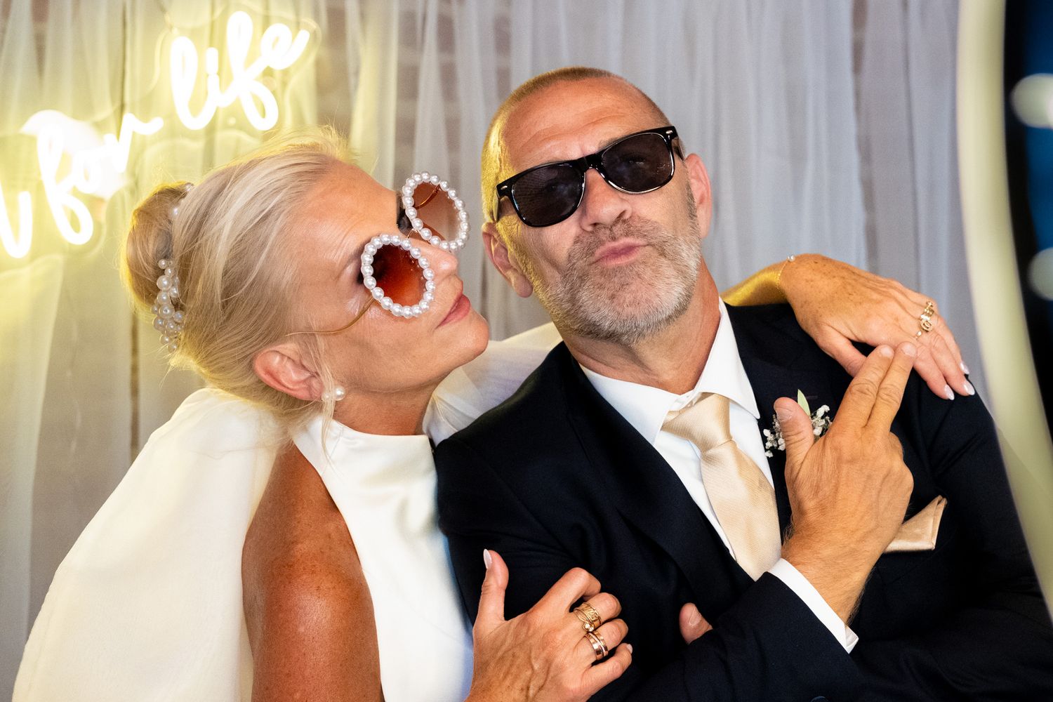 Photographie de mariage en intérieur des mariée s'amusant devant un photomaton par le photographe professionel Jérémie Botte.
