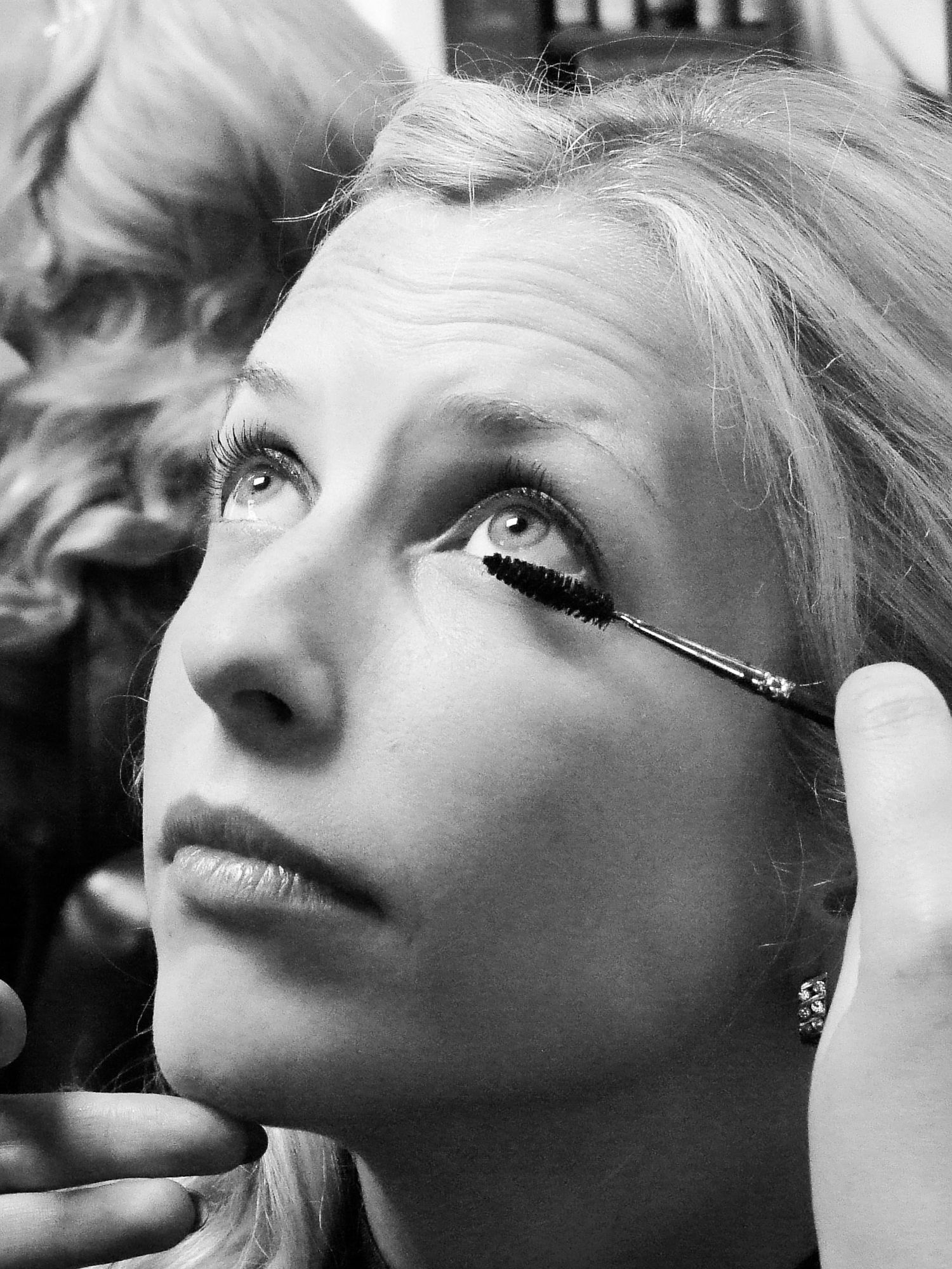 Gros plan sur une mariée se faisant appliquer du mascara par une maquilleuse, par Jérémie Botte.