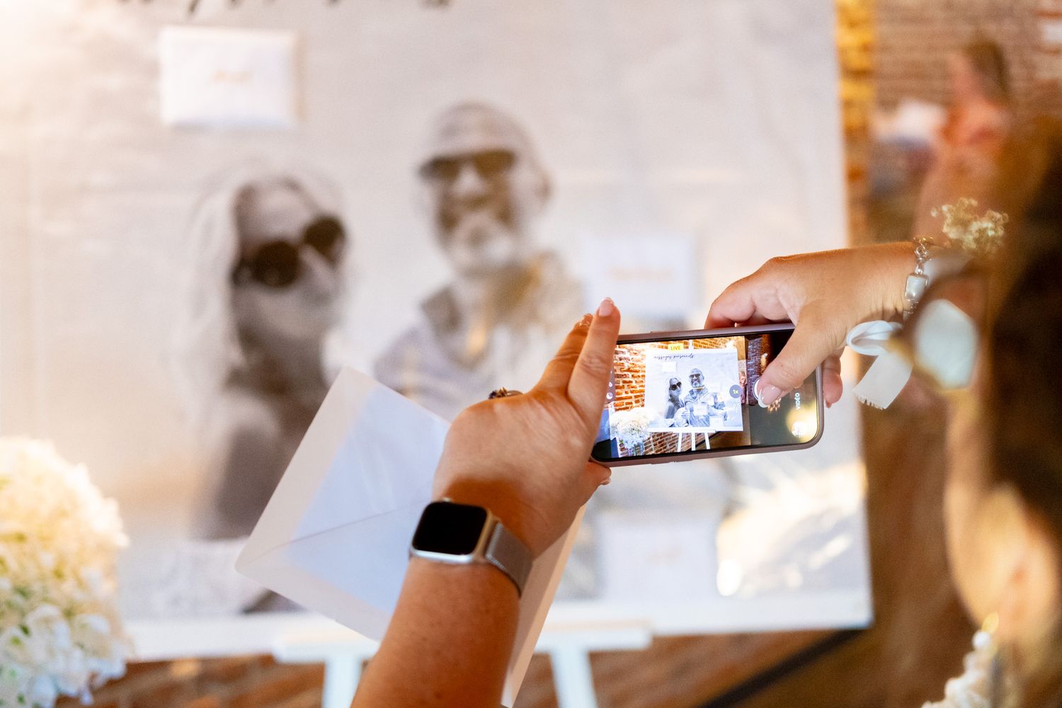 Photographie de mariage en intérieur d'un invité faisant une photo au smartphone d'une photo des mariés par le photographe Jérémie Botte.
