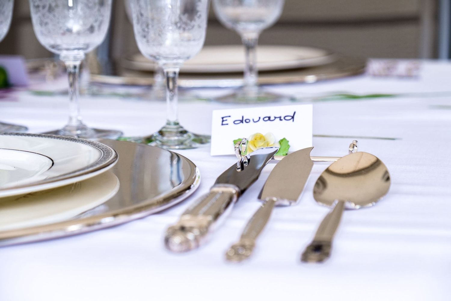 Vue rapprochée de la décoration d'une table de mariage, mettant en évidence un carton de placement au nom de 