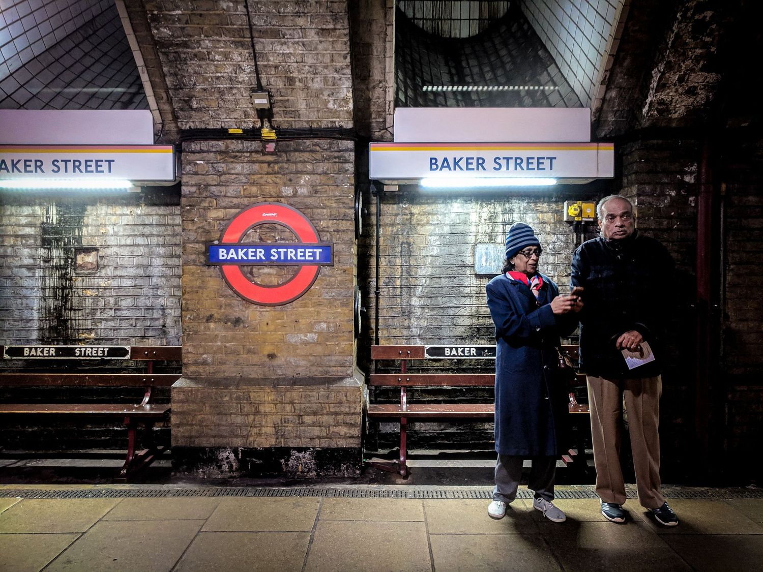 Deux passagers attendent sur le quai de la station de métro Baker Street à Londres par Jérémie Botte.