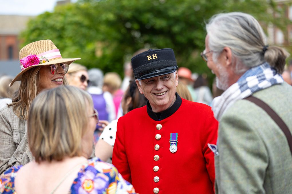 A Chelsea pensioner talking to visitors of the RHS Chelsea Flower Show in London.