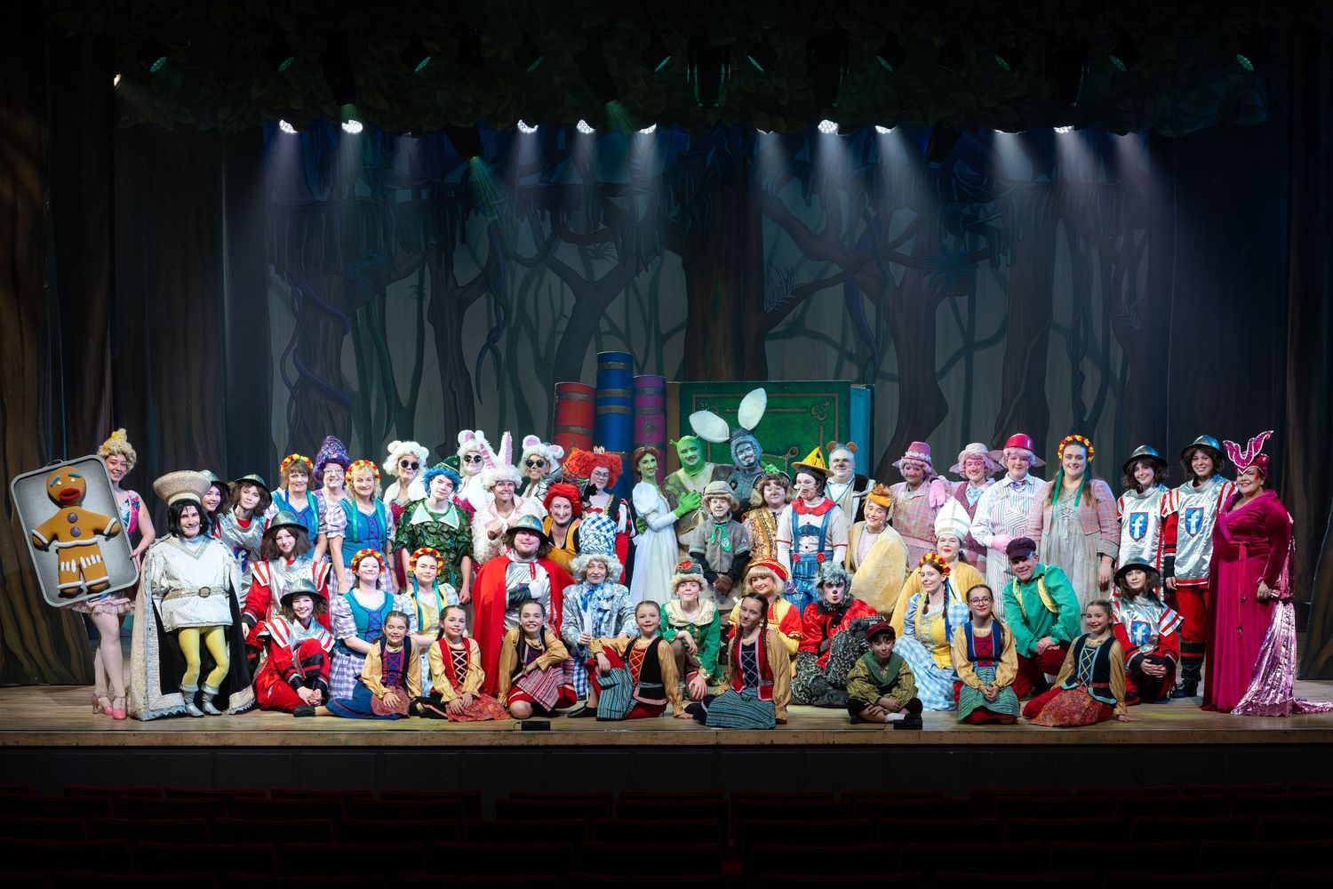 Large cast of children and adults in costume performing on stage during Shrek The Musical at Castle Theatre Wellingborough