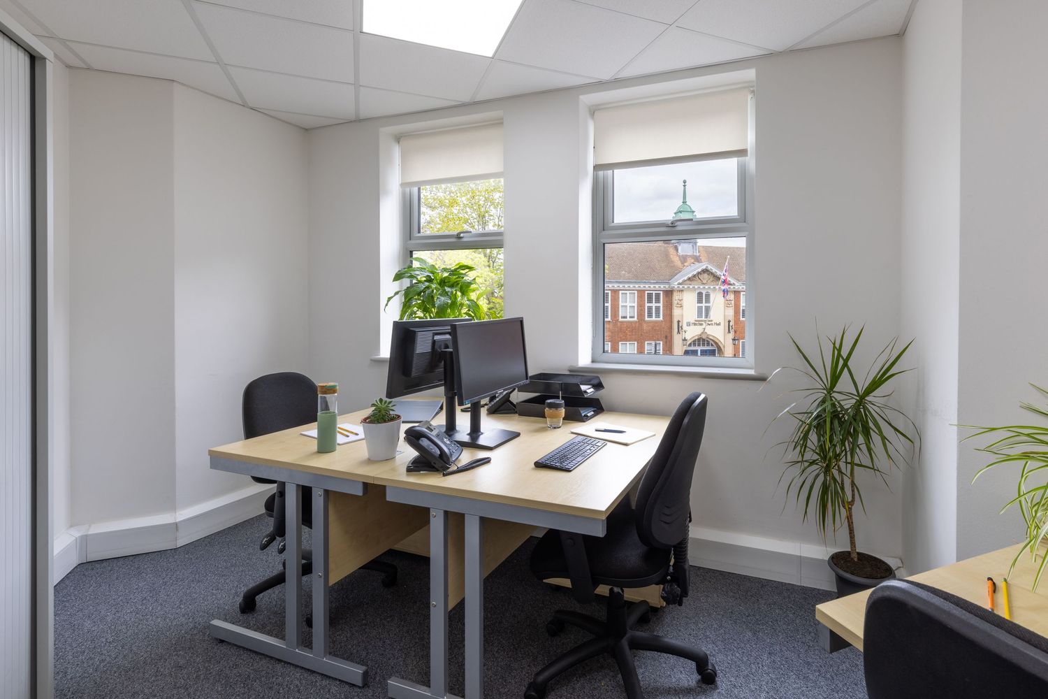Modern office interior with ergonomic workstations, natural light and contemporary workplace design for commercial photography.