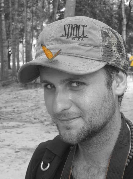 Man wearing a Space Ibiza cap in a black and white photo with selective color orange logo detail.