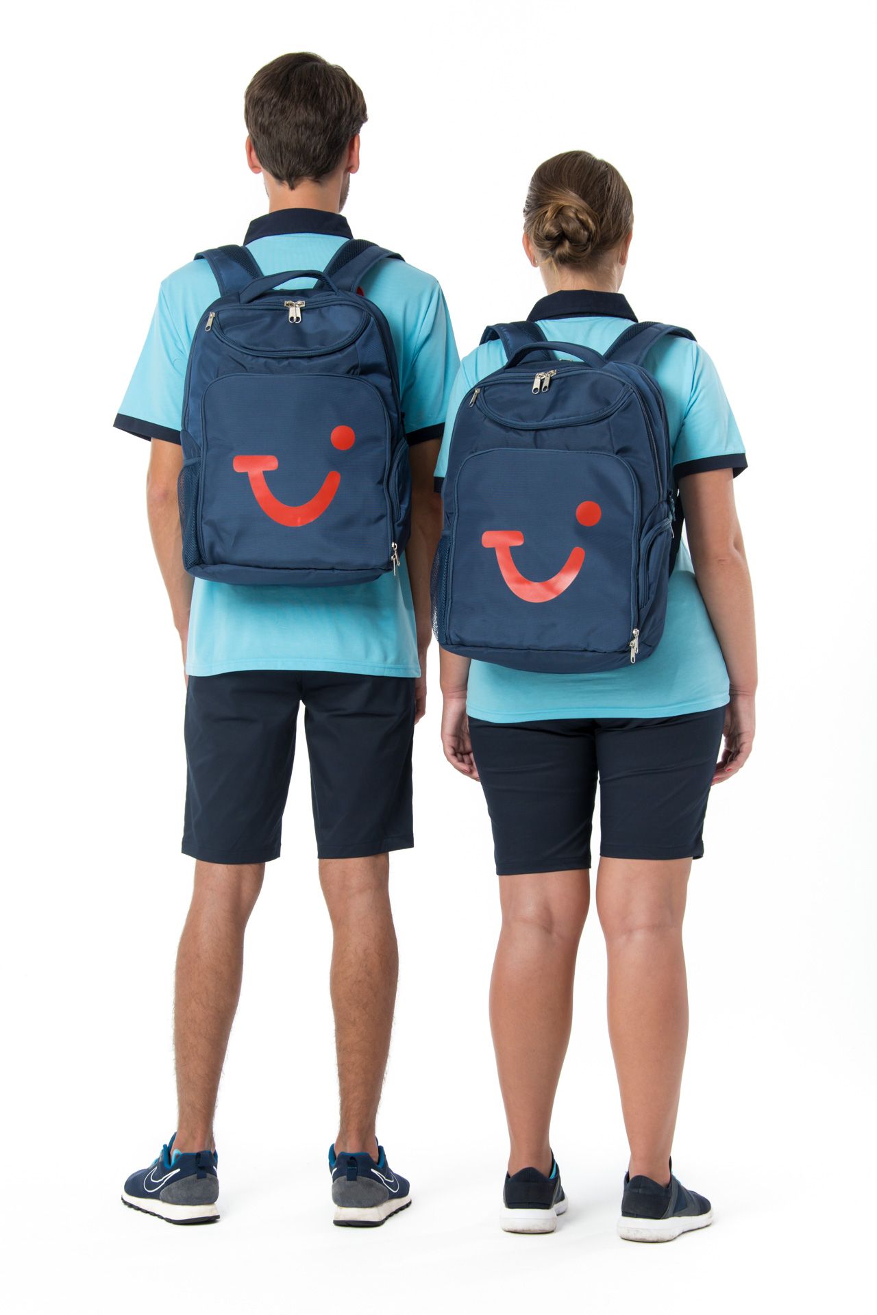 A uniform shoot where two people wearing matching TUI backpacks showcasing the TUI Smile stand back-to-back.