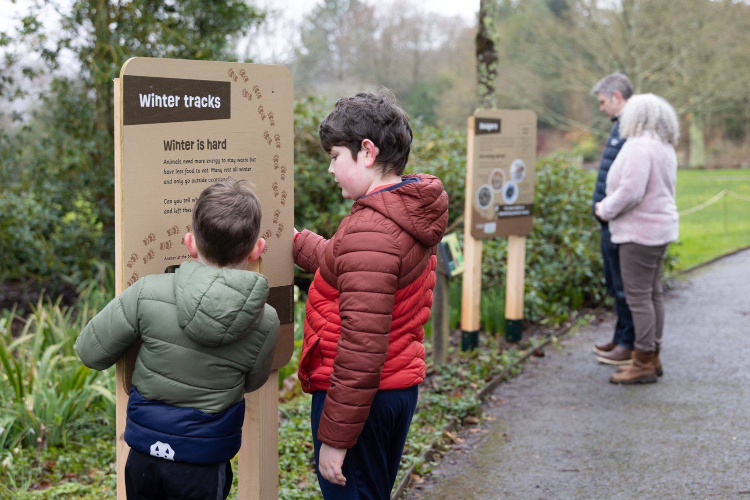 Lifestyle photography of a family exploring the Wind in the Willows adventure trail at RHS Rosemoor garden visitor attraction