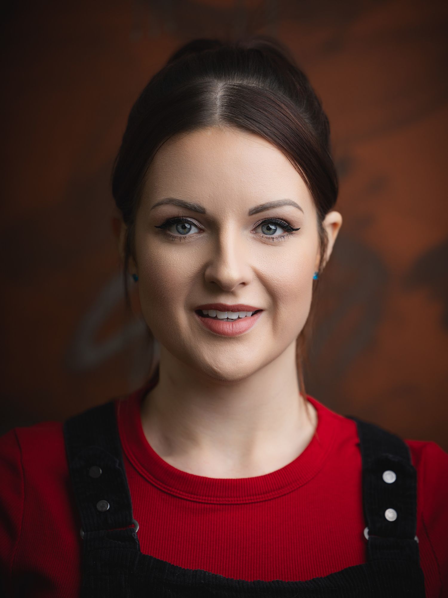 Professional headshot of a smiling woman against a studio backdrop, photographed for personal branding and business profiles.