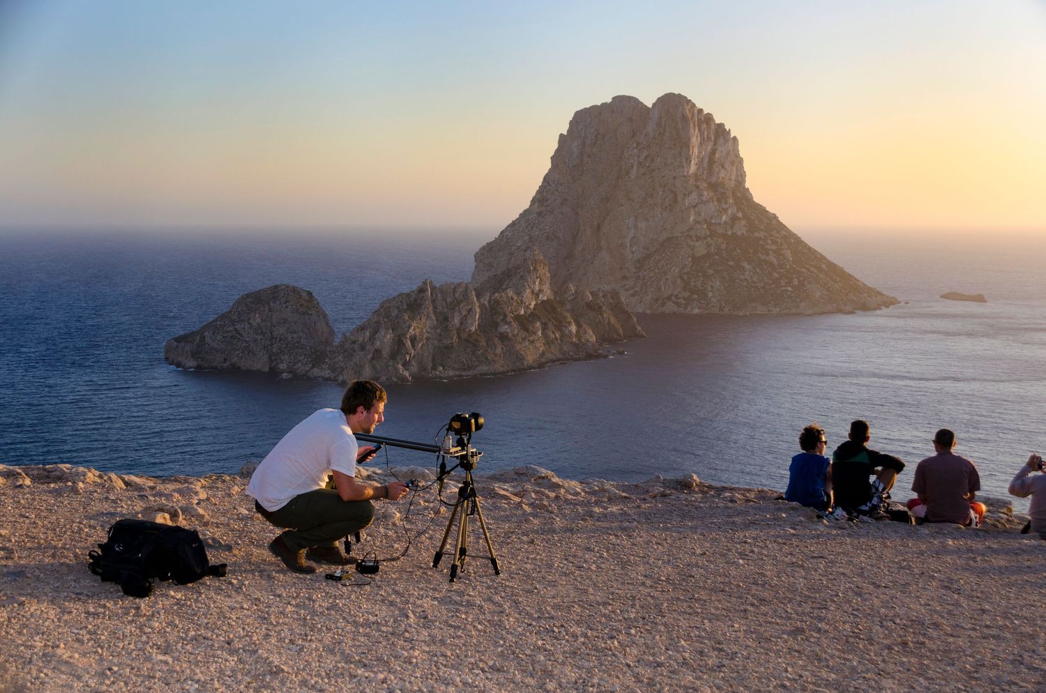 A photographer capturing the sunset at Es Vedrà, showcasing travel and tourism photography at one of Ibiza's most iconic coastlines.